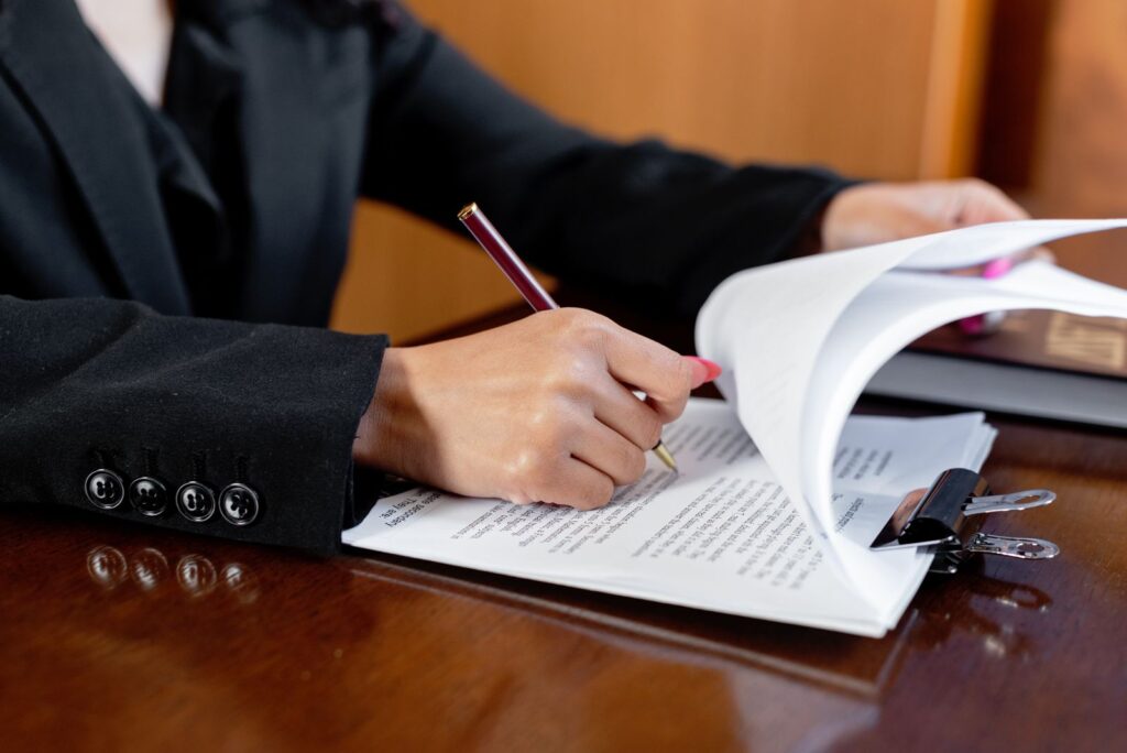 Persona firmando documentos en una notaría